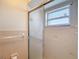 A bathroom featuring a frosted glass sliding door shower and tiled walls at 9425 Sterling Ln, Port Richey, FL 34668