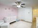 Charming Bedroom with a custom pink accent wall, white crib, and cozy furnishings at 9425 Sterling Ln, Port Richey, FL 34668