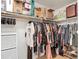 Walk-in closet with many clothes hung and boxes stacked high on a shelf at 9425 Sterling Ln, Port Richey, FL 34668