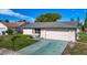 Well-kept single-story home with green-grey roof, white siding, and two-car garage at 9425 Sterling Ln, Port Richey, FL 34668