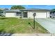 A well-maintained single-story home with a lush front yard and a two-car garage at 9425 Sterling Ln, Port Richey, FL 34668