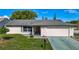 Charming single-story home featuring a well-maintained lawn, classic brick facade, and an attached two-car garage at 9425 Sterling Ln, Port Richey, FL 34668