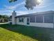 Exterior view of the house featuring a chimney and screened-in porch at 9425 Sterling Ln, Port Richey, FL 34668