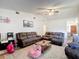 Comfortable living room with plush seating, vaulted ceiling, and wood-look flooring throughout the space at 9425 Sterling Ln, Port Richey, FL 34668