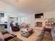 Spacious living room with white brick fireplace, cozy seating, and adjacent eat-in kitchen at 9425 Sterling Ln, Port Richey, FL 34668