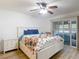 Bright main bedroom featuring wood floors, a large bed, and a sliding glass door to the lanai at 9425 Sterling Ln, Port Richey, FL 34668