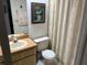 Well-lit bathroom featuring a neutral vanity, toilet, and decorative shower curtain at 9474 Nakoma Way # E, Weeki Wachee, FL 34613