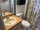 Cozy bathroom featuring a classic vanity, toilet, and a charming floral shower curtain at 9474 Nakoma Way # E, Weeki Wachee, FL 34613