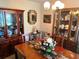 Warm dining room features a wood table, china cabinets filled with dishware and servingware, and a decorative mirror at 9474 Nakoma Way # E, Weeki Wachee, FL 34613