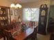 Bright dining room featuring a chandelier, grandfather clock, wood table and chairs, and china cabinet at 9474 Nakoma Way # E, Weeki Wachee, FL 34613