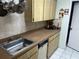 Galley kitchen featuring a stainless steel sink and wood cabinets at 9474 Nakoma Way # E, Weeki Wachee, FL 34613