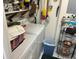 A functional laundry area with washer, dryer, storage shelves, and cleaning supplies at 9474 Nakoma Way # E, Weeki Wachee, FL 34613