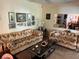 This inviting living room showcases patterned sofas, a mirrored wall, and a glass coffee table with decor at 9474 Nakoma Way # E, Weeki Wachee, FL 34613