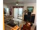 Cozy living room featuring a patterned sofa, glass coffee table, sliding glass doors, and vintage decor at 9474 Nakoma Way # E, Weeki Wachee, FL 34613