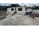 Charming single-story home with white siding, red shutters, and a spacious cracked driveway, near a detached garage at 10654 Holgate St, New Port Richey, FL 34654