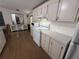 Bright kitchen features white cabinets, modern appliances, wood-look floors and ample counter space for meal preparation at 10654 Holgate St, New Port Richey, FL 34654
