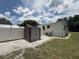 Backyard shed next to the house with a white fence surrounding the back yard at 10654 Holgate St, New Port Richey, FL 34654