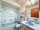 Charming blue bathroom with tiled tub and shower, blue fixtures, and unique marble-style sink at 11094 Auburndale St, Spring Hill, FL 34609