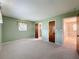 Bedroom featuring light green walls, plush carpet flooring, and doorways to other areas of the home at 11094 Auburndale St, Spring Hill, FL 34609