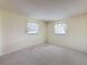 Empty bedroom features plush carpet flooring and two windows that provide natural light at 11094 Auburndale St, Spring Hill, FL 34609