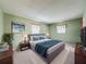 Staged bedroom featuring neutral green paint, a comfortable bed and a decorative plant at 11094 Auburndale St, Spring Hill, FL 34609