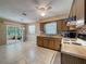 Bright kitchen featuring tile flooring, wood cabinets, and access to an outdoor patio at 11094 Auburndale St, Spring Hill, FL 34609