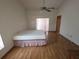 A cozy bedroom with wood floors, ceiling fan, and sliding glass door to the outside at 11263 Murraysville Dr, Spring Hill, FL 34609