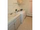 A laundry room with a washing machine, utility sink, and cabinets at 11263 Murraysville Dr, Spring Hill, FL 34609