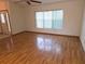 Open living room featuring hardwood floors, a ceiling fan, and large windows for ample natural light at 11263 Murraysville Dr, Spring Hill, FL 34609