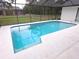 Cool, clear, blue pool enclosed in a screened lanai is perfect for a relaxing swim at 11263 Murraysville Dr, Spring Hill, FL 34609