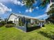 A charming backyard with manicured lawn and a view of the home's exterior at 11622 White Ash Dr, New Port Richey, FL 34654