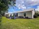 A charming backyard with manicured lawn and a view of the home's exterior at 11622 White Ash Dr, New Port Richey, FL 34654