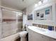Bathroom with tiled walls, glass shower doors, updated sink, and nautically themed art at 11622 White Ash Dr, New Port Richey, FL 34654