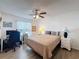 Cozy bedroom with a ceiling fan, soft lighting, wood floors, and ample space for a functional workspace at 11622 White Ash Dr, New Port Richey, FL 34654
