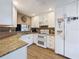 Bright kitchen featuring white cabinetry, stainless appliances, and granite countertops, complemented by wood flooring at 11622 White Ash Dr, New Port Richey, FL 34654