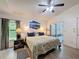 Main bedroom with wood floors, mountain artwork, ceiling fan, and side tables at 11622 White Ash Dr, New Port Richey, FL 34654