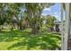 Lush backyard with mature trees, offering ample shade and a peaceful outdoor setting at 11725 Spring Tree Ln, Port Richey, FL 34668