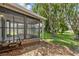 Exterior view of a screened lanai complemented by rock landscaping and mature trees at 11725 Spring Tree Ln, Port Richey, FL 34668