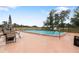 Community pool with ample seating and lounge chairs, perfect for a refreshing swim and relaxation at 11725 Spring Tree Ln, Port Richey, FL 34668