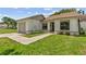 Close up exterior view of single-story home with manicured lawn and attached one car garage at 11725 Spring Tree Ln, Port Richey, FL 34668