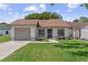 Charming single-story home with manicured lawn, inviting entryway, and attached one car garage at 11725 Spring Tree Ln, Port Richey, FL 34668