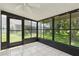 Enclosed lanai offering a relaxing space with tile flooring and views of the lush backyard at 11725 Spring Tree Ln, Port Richey, FL 34668