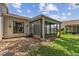 Exterior view of the screened lanai surrounded by well-maintained landscaping and lush greenery at 11725 Spring Tree Ln, Port Richey, FL 34668