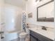 Bright bathroom featuring a shower-tub combo, decorative mirror, and charming coastal-themed accents at 12119 Barnsley Reserve Pl, Gibsonton, FL 33534