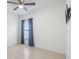 Bedroom featuring tile flooring, a ceiling fan, blue curtains, and a decorative wall fixture at 12119 Barnsley Reserve Pl, Gibsonton, FL 33534