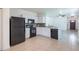 Contemporary kitchen with white cabinets, black appliances, and tile flooring at 12119 Barnsley Reserve Pl, Gibsonton, FL 33534