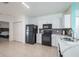 Modern kitchen featuring white cabinets, black appliances, and tile flooring at 12119 Barnsley Reserve Pl, Gibsonton, FL 33534
