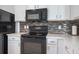 This modern kitchen features black appliances, quartz countertops, and a tiled backsplash at 12119 Barnsley Reserve Pl, Gibsonton, FL 33534