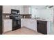 The bright kitchen features white cabinets, quartz countertops, and modern black appliances at 12119 Barnsley Reserve Pl, Gibsonton, FL 33534