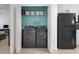 A laundry room features appliances and plenty of shelving for organizing your needs at 12119 Barnsley Reserve Pl, Gibsonton, FL 33534